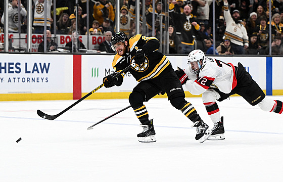 David Pastr�ák (88) z Boston Bruins st�ílí na bránu Ottawa Senators, stíhá ho...