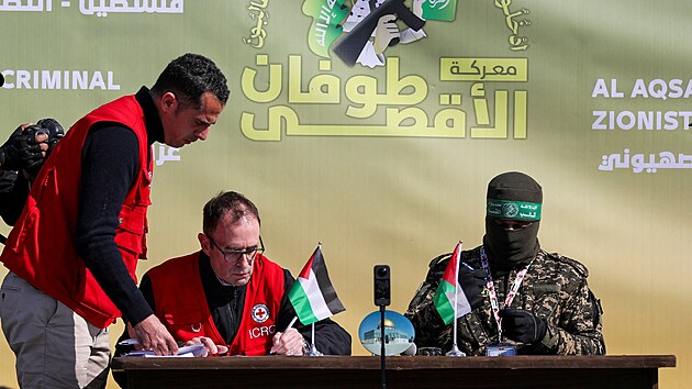 �len Mezin�rodn�ho v�boru �erven�ho k��e podepisuje dokument, kdy� se bojovn�ci Ham�su p�ipravuj� p�edat �ty�i izraelsk� voj�kyn�, kter� byly zadr�ov�ny v Gaze. (25. ledna 2025)