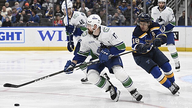 Filip Hronek (17) z Vancouveru faulovaný Robertem Thomasem ze St. Louis.