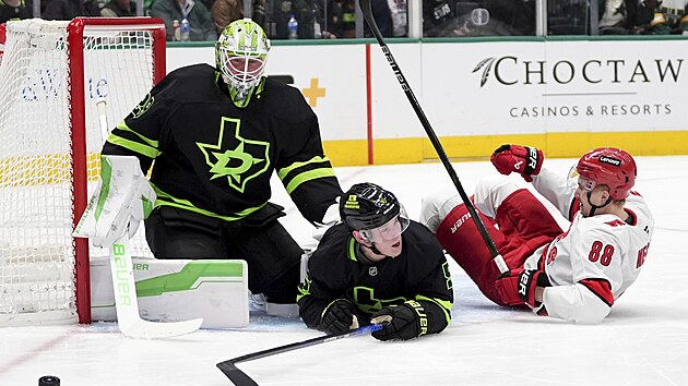 Martin Ne�as (88) z Carolina Hurricanes se v�l� na led� p�ed br�nou Jakea Oettingera z Dallas Stars.