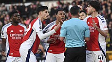 Fotbalisté Arsenalu diskutují s rozhodím Michaelem Oliverem po vylouení...