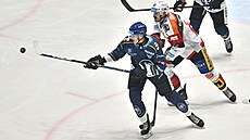 Kladenský Tomá� Vandas se natahuje pro puk p�ed pardubickým Milo�em Kelemenem.