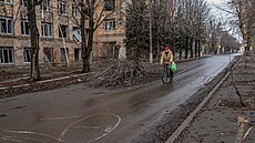 Obyvatel jede na kole kolem budovy po�kozené ruskými vojenskými údery v...