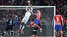 Branká� Leverkusenu Mat�j Ková� boxuje balon p�ed nabíhajícími hrá�i Atlétika...