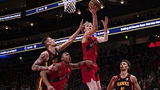 Vít Krej�í (v �erném) z Atlanty �plhá po zádech torontského Scottieho Barnese,...