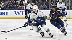Filip Hronek (17) z Vancouveru faulovaný Robertem Thomasem ze St. Louis.