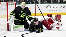 Martin Ne�as (88) z Carolina Hurricanes se válí na led� p�ed bránou Jakea...