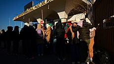 Zábr z americko-mexických hranic, kolumbijtí migranti se objímají poté, co...