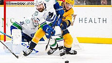 Obránce Filip Hronek z Vancouver Canucks bojuje o puk v utkání s Nashville...