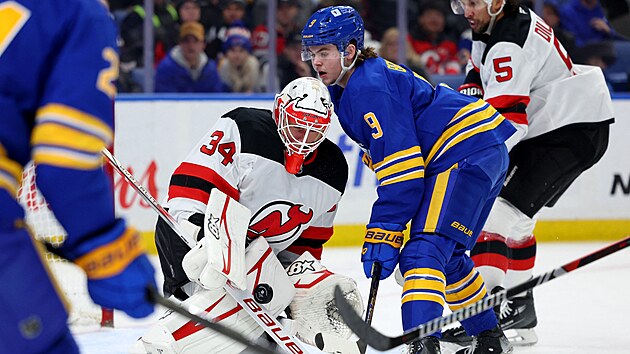 Brank�� Jake Allen z New Jersey zasahuje p�ed Zachem Bensonem z Buffala.