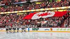 Fanou�ci Ottawa Senators si p�edávají kanadskou vlajku p�ed zápasem s Minnesota...