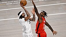 Anthony Davis z Dallas Mavericks st�ílí p�es blokujícího Tariho Easona z...