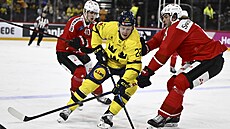 Fredrik Olofsson ze �védska se sna�í projít p�es �výcarské protihrá�e.