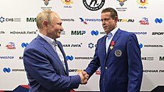 Bývalý hokejista Pavel Bure (vpravo) p�ijímá od ruského prezidenta Vladimira...