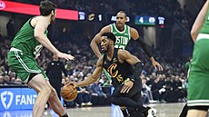 Donovan Mitchell dribluje mezi obránci Bostonu.