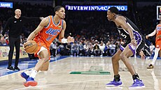 Aaron Wiggins (vlevo) z Oklahomy se sna�í projít p�es De�Aarona Foxe ze...
