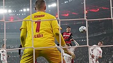 �eský úto�ník Patrik Schick z Leverkusenu hlavi�kuje p�es kolínského obránce a...
