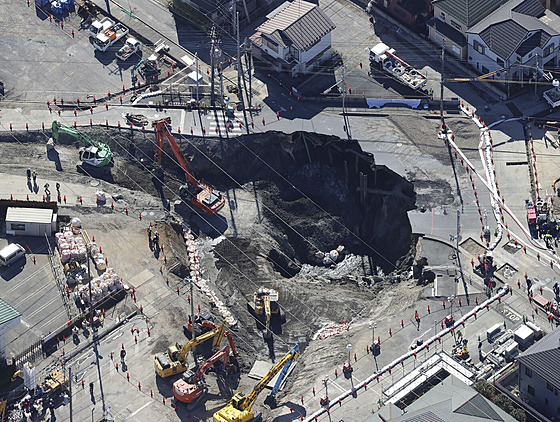 D�lníci s bagrem hledají �idi�e, který spadl do díry ve m�st� Ja�io nedaleko...