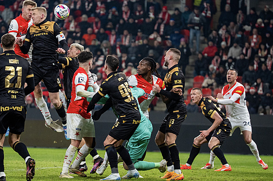 Ostravský branká� Dominik Holec padá po souboji se slávistou Igohem Ogbuem....