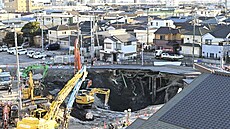 D�lníci s bagrem hledají �idi�e, který spadl do díry ve m�st� Ja�io nedaleko...