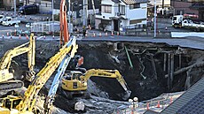 D�lníci s bagrem hledají �idi�e, který spadl do díry ve m�st� Ja�io nedaleko...