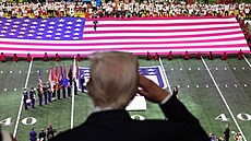 Donald Trump salutuje americké vlajce ped Super Bowlem.