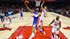 Cade Cunningham z Detroitu zakon�uje na ko� Chicaga kolem Matase Buzelise (14).