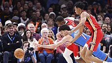 Chet Holmgren (v modrém) z Oklahoma City Thunder se vrhá po mí�i v zápase s New...