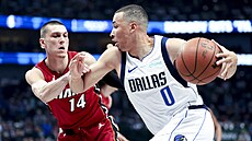 Danté Exum (0) z Dallas Mavericks se tla�í ke ko�i Miami Heat, brání ho Tyler...