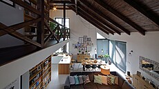 Otev�ený obývací pokoj s kuchy�kou odd�lenou pracovní plochou, u ní� se snídá....