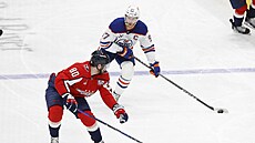Kapitán Edmontonu Connor McDavid vede puk, sleduje ho Pierre-Luc Dubois z...