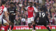 Arsenalský Thomas Partey zkou�í projít p�es fotbalisty West Hamu.