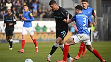 Patrik Schick z Leverkusenu se sna�í p�ejít p�es Marca Komenda z Kiele.