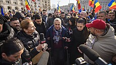 Policisté vedou prezidentského kandidáta Georgeska k výslechu. (26. února 2025)