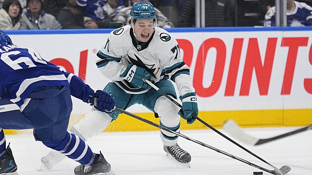 Macklin Celebrini ze San Jose Sharks kli�kouje kolem Davida K�mpfa z Toronto Maple Leafs.