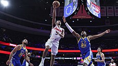 Quentin Grimes z Philadelphie ská�e ke ko�i. Bránit se mu sna�í Stephen Curry...
