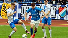 Mladoboleslavský Matyá� Vojta se sna�í projít mezi fotbalisty ostravského...