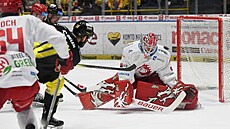 Litvínovský Petr Koblasa (v �erném) pálí, branká� T�ince Ond�ej Kacetl zasahuje.