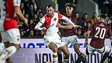 Tomá� Chorý ze Slavie se otá�í za balonem, zastavit se ho sna�í Kaan Kairinen...