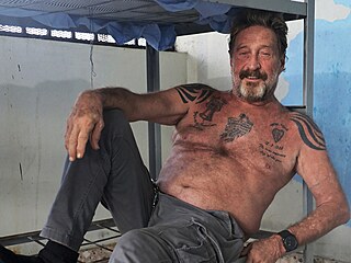 John McAfee ve vzení v Barcelon v roce 2020 poád vil v moc armády svých...