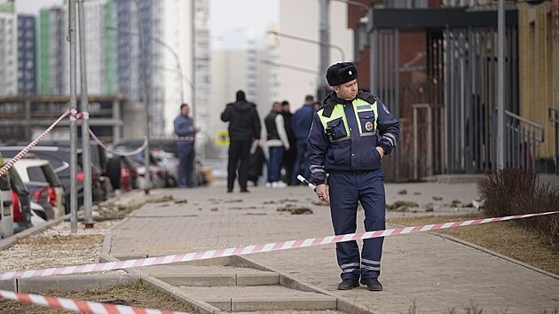 Policista hl�dkuje v rusk� vesnici Sapronovo u Moskvy v bl�zkosti obytn�ho domu, kam spadl sest�elen� ukrajinsk� dron. (11. b�ezna 2025)