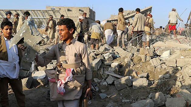 Lid� se shroma��uj� na trosk�ch domu zasa�en�ho americk�m �derem v jemensk� Saad�. (16. b�ezna 2025)