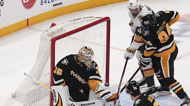 Tom� Hertl (v b�l�m) z Vegas Golden Knights tla�� puk do br�ny Pittsburgh Penguins, ve kter� kle�� Tristan Jarry (35).