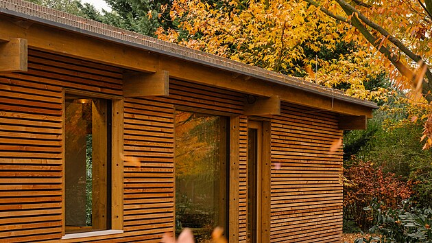 D�m s plochou st�echou a d�ev�nou fas�dou sv�m um�st�n�m respektuje p�vodn� stavbu i pe�liv� ope�ov�vanou zele�. 