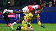 Slávistický stoper Igoh Ogbu p�epadává p�es gólmana Jablonce Jana Hanu�e, který...
