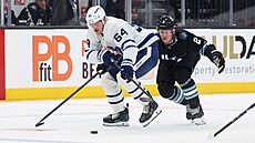 David Kämpf (64) z Toronto Maple Leafs útoí v zápase s Utahem, stíhá ho Olli...