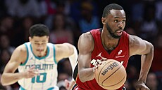 Andrew Wiggins z Miami Heat úto�í na ko� Charlotte Hornets. Stíhá ho Josh Green.