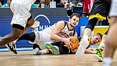 Jaromír Bohačík (v bílém) z Nymburka bojuje o míč v zápase se Szombathely.
