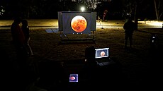 Lidé sledují na obrazovce videop�enos úplného zatm�ní M�síce v Humboldtov�...