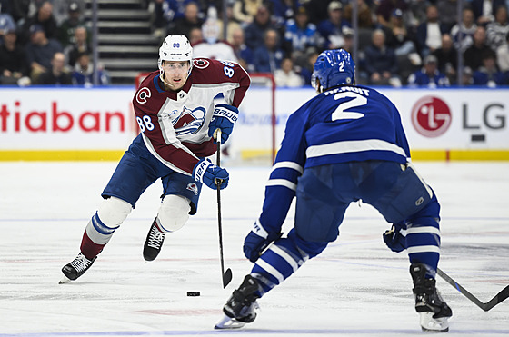 Martin Ne�as z Colorado Avalanche se blí�í k obránci Simonu benoitovi z Toronto...